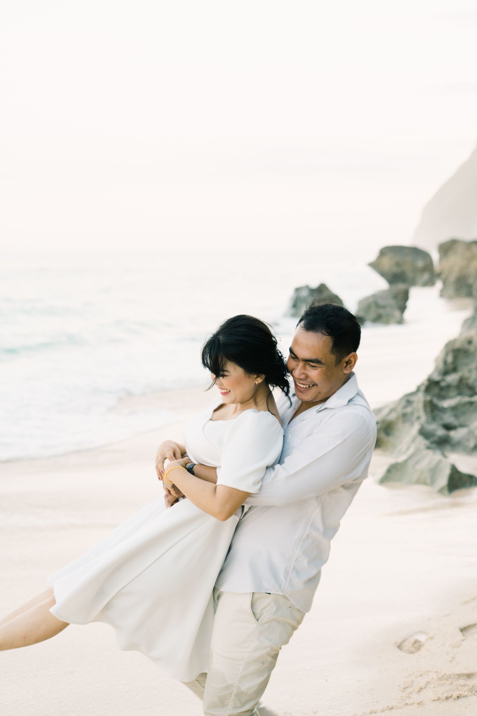 A playful couple embracing on the coast