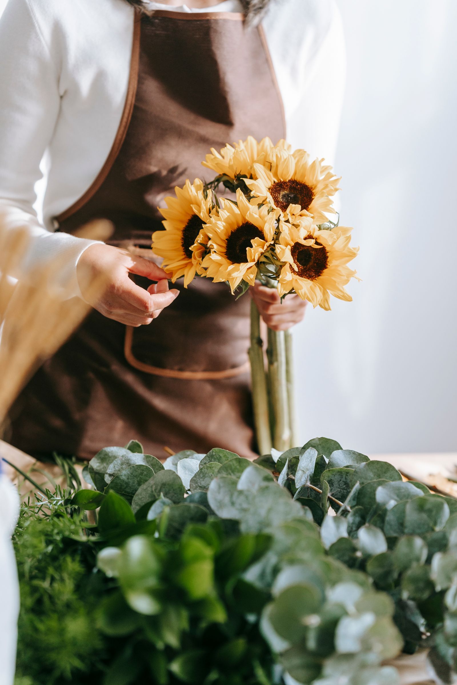 Florist making a floral bouquet with sunflowers