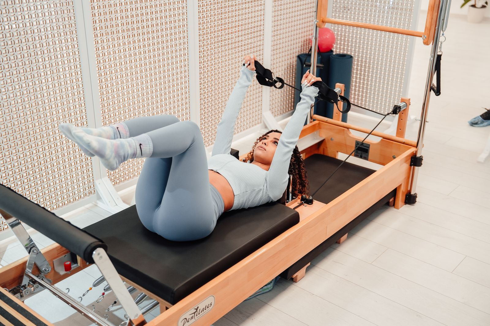 Woman on a reformer pilates machine in natural light
